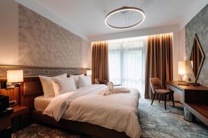 a hotel room with a large bed and a desk at HOTEL CRYSTAL WELLNESS & SPA superior in Sovata