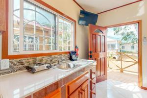 a kitchen with a sink and a window at Hummingbird Estate in Dangriga