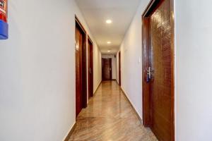 an empty hallway with wooden floors and doors at Flagship Silver Suites in Bangalore