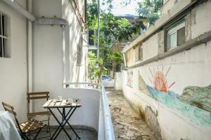 an alley with a table and a wall with a painting at Charming 2 BR in the Heart of Haifa by Sea N Rent in Haifa
