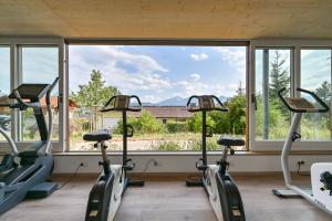- une rangée de vélos d'exercice dans une chambre avec fenêtre dans l'établissement Biohotel Eggensberger, à Füssen