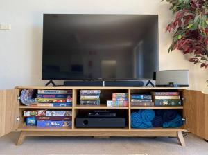 a wooden entertainment center with a flat screen tv at Shoreline Unit 8 in Tuncurry