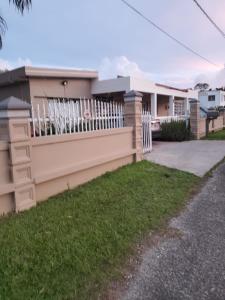 uma cerca em frente a uma casa em Heidy House em Arecibo