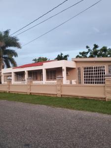 a house with a fence in front of it at Heidy House in Arecibo