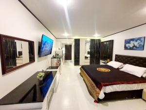 um quarto com uma cama grande e uma televisão de ecrã plano em Sea Sand Sun Resort em Rayong