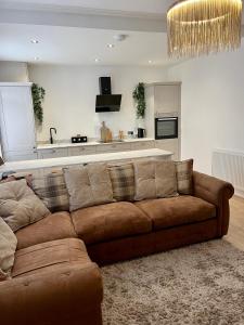 a living room with a brown couch and a kitchen at Coastal Apartments No 2 in Seaham