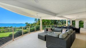 a living room with a couch and a balcony at Island Point Villa 1 Port Douglas in Port Douglas