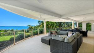 ポートダグラスにあるIsland Point Villa 1 Port Douglasのソファとバルコニーのあるリビングルーム