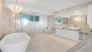 a white bathroom with two sinks and a shower at Island Point Villa 1 Port Douglas in Port Douglas