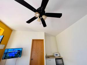 Habitación con ventilador de techo y cocina. en Casa Alcalde Alojamiento centro Guadalajara en Guadalajara