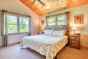 een slaapkamer met een bed en 2 ramen bij Tranquility Too Cabin & Tranquility Too Cottage in Waynesville