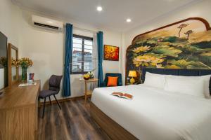 a hotel room with a bed and a painting on the wall at The Sono Hanoi Hotel in Hanoi