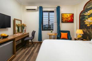 a hotel room with a bed and a desk and a window at The Sono Hanoi Hotel in Hanoi
