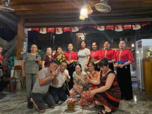 Un groupe de personnes pose une photo dans l'établissement Cò's House, à Mai Châu