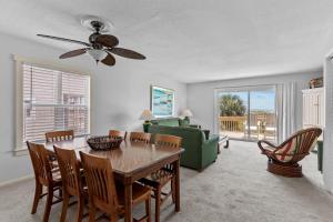 a dining room with a table and chairs and a couch at Bayview East & West in Holden Beach