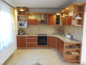 a large kitchen with wooden cabinets and appliances at domek PERKUN in Pierkunowo