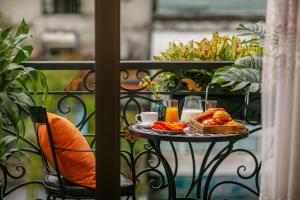 a table with food and drinks on a balcony at The Sono Hanoi Hotel in Hanoi