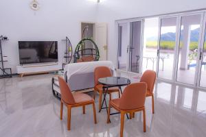 a room with a bed and chairs and a tv at Lake Side Villa in Nadi