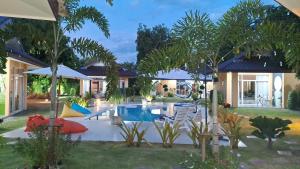 une cour avec une piscine bordée de chaises et d'arbres dans l'établissement Pool Villa, Resort, Mae Ramphueng Beach, Ban Phe, Rayong, Residence M Thailand, à Ban Chamrung