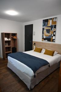 a bedroom with a large bed in a room at Cit'Hotel Les Eleis in Saint-Martin-de-Fraigneau