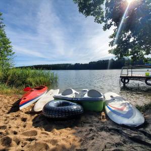 a group of boats sitting on the shore of a lake at Villa nad Kalwą in Tylkowo