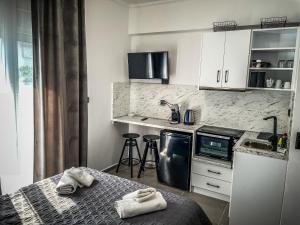 a kitchen with white cabinets and a table with towels at The Room in Xanthi