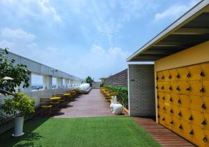 an outdoor patio with chairs and green grass at Hotel Marinabay Seoul Ara in Gimpo