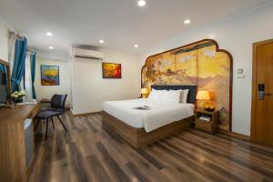 a hotel room with a large bed and a desk at The Sono Hanoi Hotel in Hanoi
