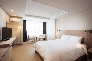 Łóżko lub łóżka w pokoju w obiekcie Crown Harbor Hotel Busan
