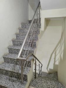 a staircase with a metal handrail and a stair case at OYO Hotel Ambar Inn in Phagwāra