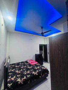 a bedroom with a blue ceiling and a bed at OYO Hotel Ambar Inn in Phagwāra