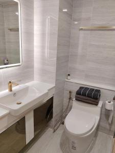 ein weißes Badezimmer mit Toilette und Waschbecken in der Unterkunft A studios精致的漂亮的房间可做饭 in Nong Prue