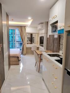 eine Küche mit weißen Schränken und ein Bett in einem Zimmer in der Unterkunft A studios精致的漂亮的房间可做饭 in Nong Prue + 18 Fotos