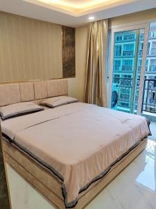 ein großes Bett in einem Zimmer mit Fenster in der Unterkunft A studios精致的漂亮的房间可做饭 in Nong Prue