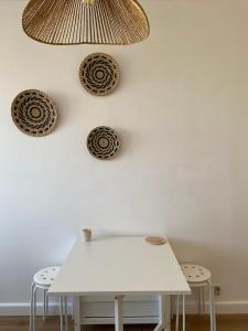 une table blanche et deux tabourets contre un mur blanc dans l'établissement Studio moderne avec vue mer - Pietranera - Proche Bastia, à Pietranera