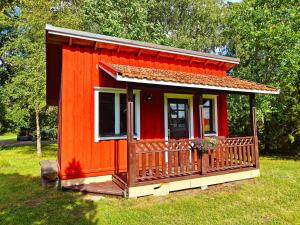 czerwony domek na polu trawy w obiekcie JUST Lodges w mieście Orissaare