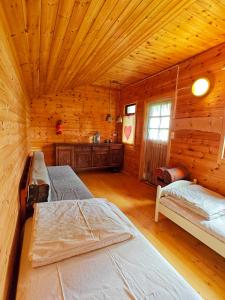 a bedroom with two beds in a log cabin at JUST Lodges in Orissaare