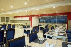 a restaurant with tables and chairs and a kitchen at VOVO PREMIER HOTEL in Bangalore