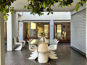 una sala da pranzo con tavolo e sedie in vetro di Villa Moderna Exclusiva con Jardín Privado La Villa de Sevilla a Guillena