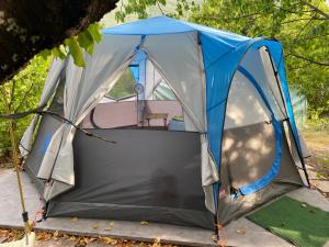 une tente bleue et grise avec une table. dans l'établissement Tente à la campagne, à Roquestéron