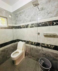 a bathroom with a toilet and a shower at OYO Flagship Sb Residency in Alleppey