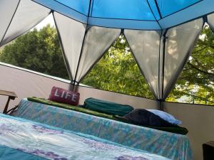 une tente avec 2 lits en face d'une fenêtre dans l'établissement Tente à la campagne, à Roquestéron