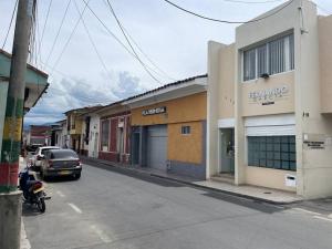 a street with a car parked in front of a building at Acogedor apartamento en Buga in Buga