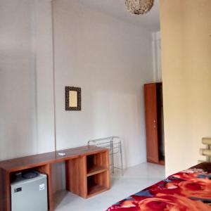 SUNRISE BUKIT ASAM HOMESTAY في كوتا لومبوك: غرفة نوم مع مكتب وسرير في غرفة