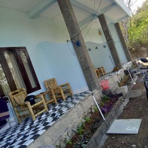 SUNRISE BUKIT ASAM HOMESTAY في كوتا لومبوك: مجموعة من الكراسي على شرفة المنزل