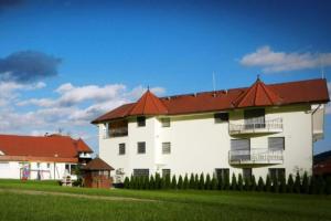 un grand bâtiment blanc avec un toit rouge dans l'établissement Honeycomb Chalets And Apartments Mozirje - Happy Rentals, à Mozirje