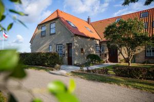 a large brick house with an orange roof at Haus im Felde Whg 6 in Fehmarn
