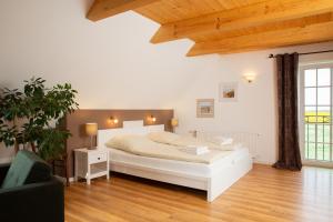 a bedroom with a white bed and a wooden floor at Haus im Felde Whg 6 in Fehmarn