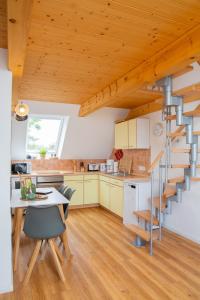a kitchen and dining room with a spiral staircase at Haus im Felde Whg 6 in Fehmarn