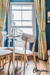 une table et des chaises devant une fenêtre dans l'établissement Trocadero Suite - Central-Royal Mile Castle, à Édimbourg